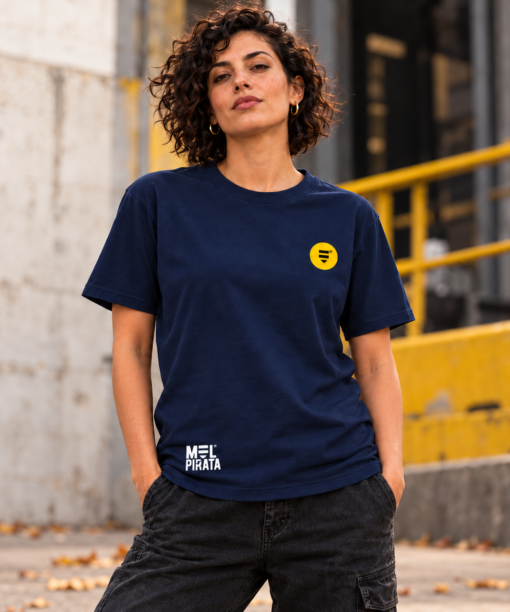 Pessoa com t-shirt azul-marinho Mel Pirata, vista de frente, com símbolo no peito e marca junto à bainha.
