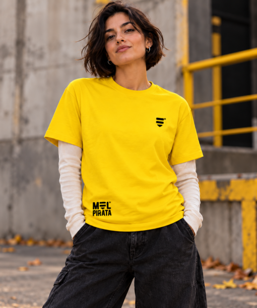 Pessoa com t-shirt amarela Mel Pirata, vista de frente, com símbolo no peito e marca junto à bainha.