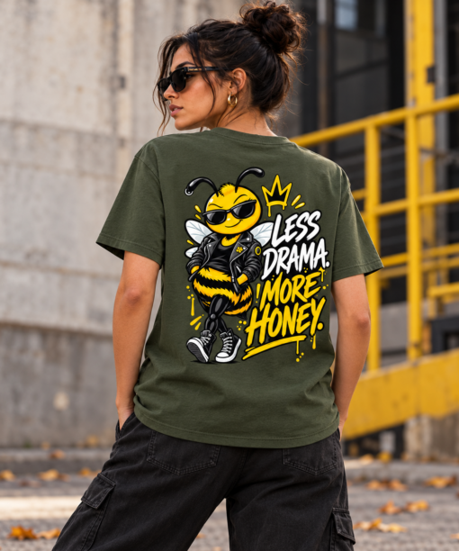 Pessoa com t-shirt verde Mel Pirata, vista de costas, com desenho da abelha Mel e frase Less Drama More Honey.