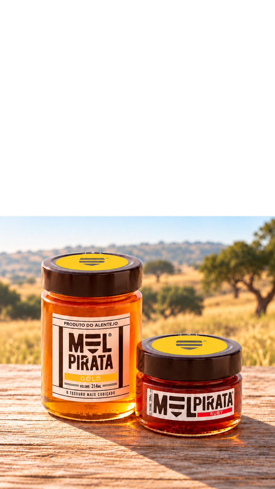 Frascos de mel Gold e Ruby da Mel Pirata sobre uma mesa de madeira, com paisagem alentejana ao fundo.